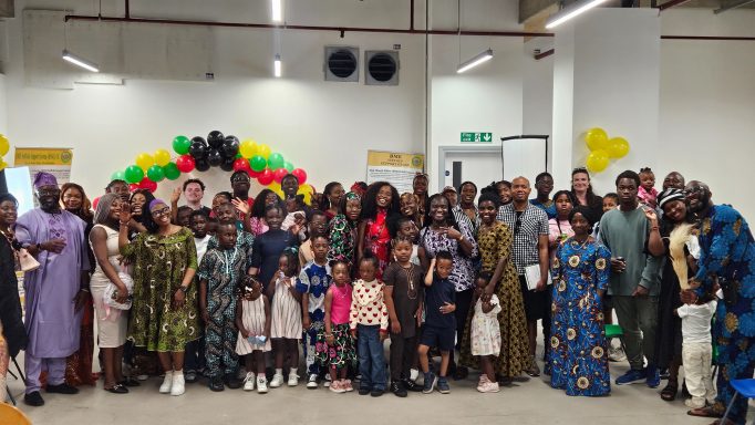 African Day Celebration A large group of people posing together, smiling, in a festive indoor setting.